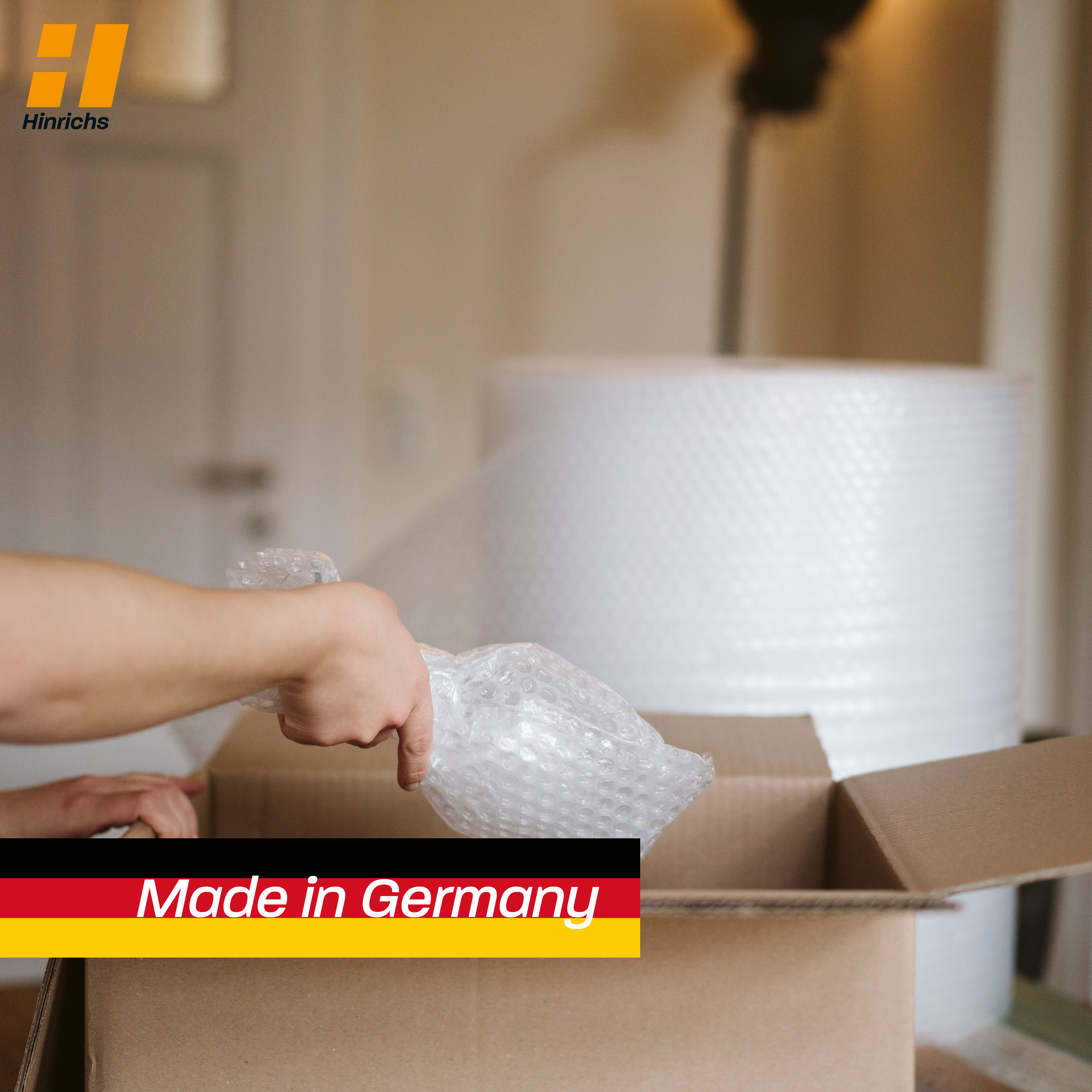 Rolle silberfarbener Luftpolsterfolie, teilweise abgerollt, aufrecht stehend vor weißem Hintergrund.